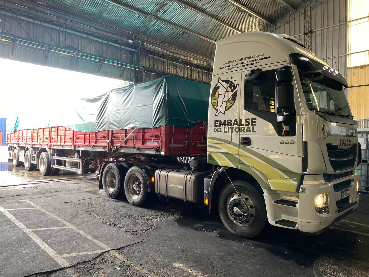 Iveco 440 de Embalse del Litoral con el ploteo institucional, enganchando semirremolque en el depósito